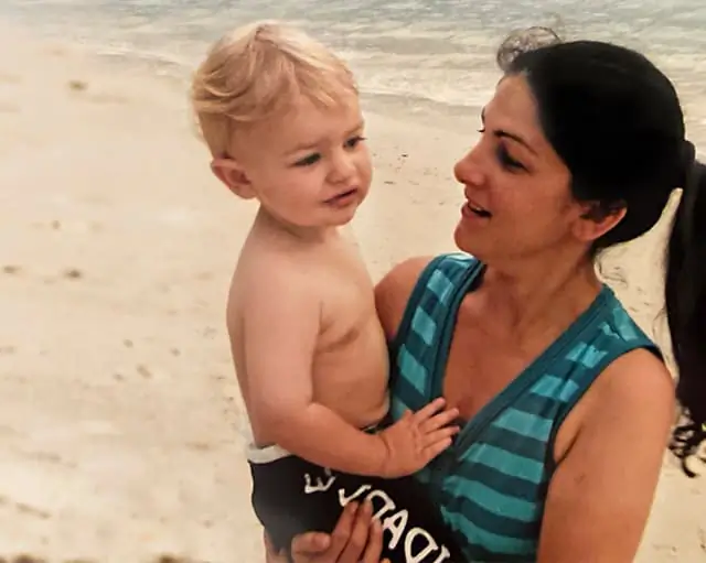 Jacqui holding her son in the beach
