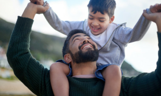 Young boy on father's shoulders.