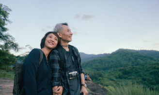 Couple in the outdoors smiling.