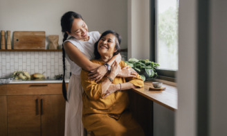 Mother and daughter embracing indoors.
